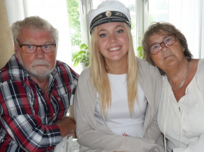 En glad och lycklig student med farfar och farmor